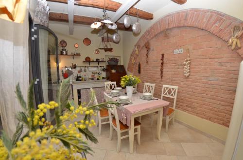 a dining room with a table and a brick wall at Al Colle Di Lari in Lari