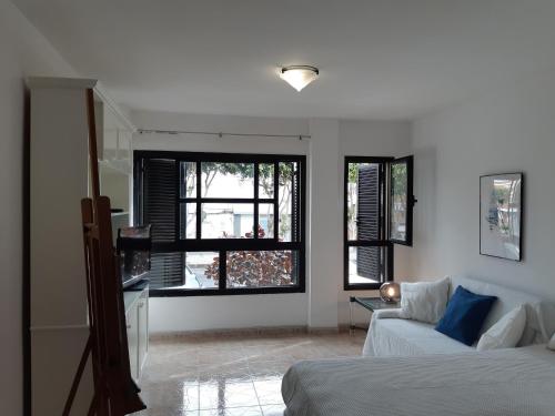 テルデにあるSalineta's homeのベッド1台、ソファ、窓が備わる客室です。