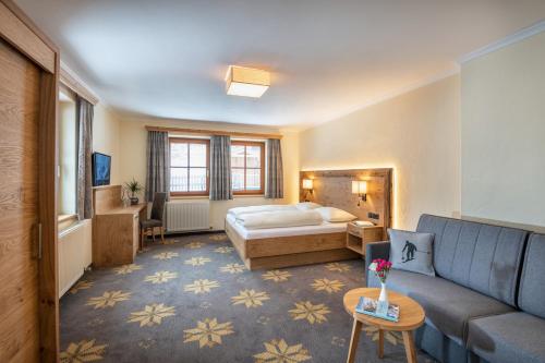 ein Hotelzimmer mit einem Bett und einem Sofa in der Unterkunft Aparthotel Weningeralm in Obertauern