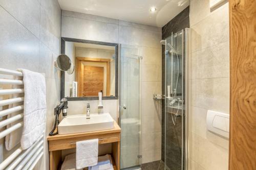 łazienka z umywalką i prysznicem w obiekcie Aparthotel Weningeralm w mieście Obertauern