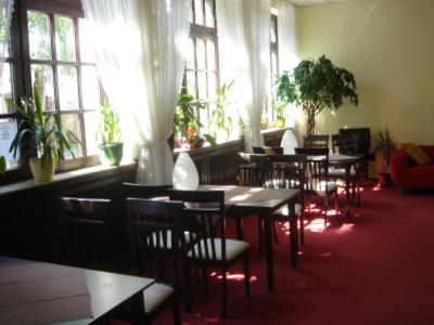 een eetkamer met tafels, stoelen en ramen bij Hotel Lintforter Hof in Kamp-Lintfort