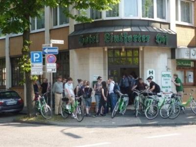 een groep mensen die buiten een gebouw staan met hun fietsen bij Hotel Lintforter Hof in Kamp-Lintfort