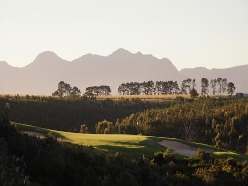 a view of a golf course with mountains in the background at Oubaai Hotel Golf & Spa in George
