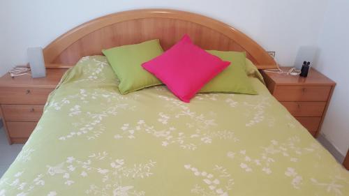 Una cama con dos almohadas de colores encima. en Valls Rent, en Andorra la Vella
