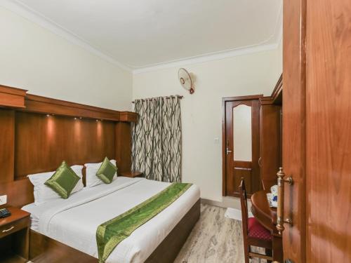 a bedroom with a bed with a wooden headboard at Le Celestium in Munnar