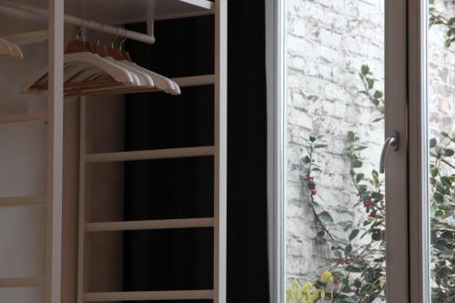 a closet with wooden shelves and a window at Hoogpoort Residence George in Ghent