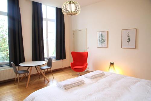 Schlafzimmer mit einem Bett, einem Tisch und Stühlen in der Unterkunft Hoogpoort Residence George in Gent