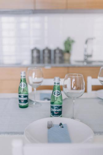 a table with two glasses and a bottle of soda at APARTEL Plac Unii Lubelskiej in Warsaw