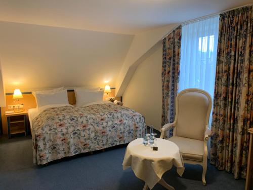 ヴァイル・アム・ラインにあるHotel-Restaurant Schwanenのベッド、椅子、テーブルが備わるホテルルームです。