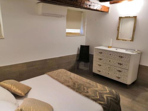 a bedroom with a bed and a dresser and a mirror at Appartamento AlCova in Venice