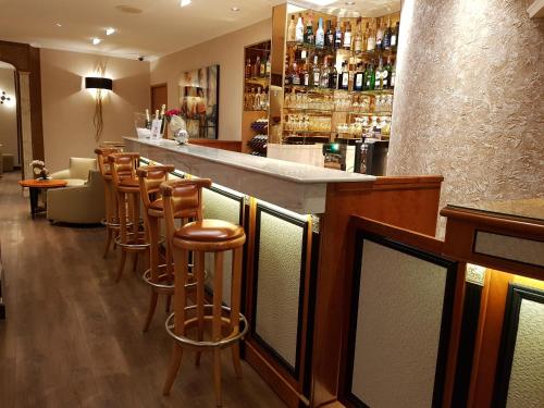 a bar with a row of stools in a restaurant at Hotel Champerret Elysees in Paris