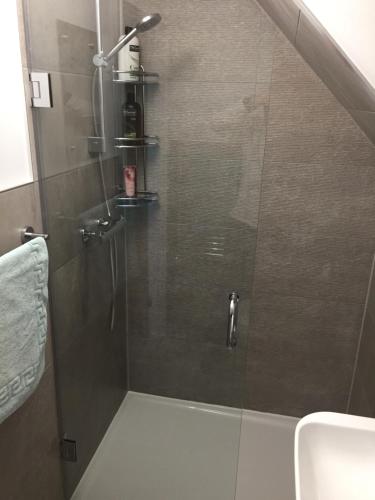 a shower with a glass door in a bathroom at Oliver's Studio at Oliver's Yard in Shipton under Wychwood