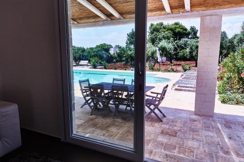 a patio with a table and chairs and a pool at Trullo Felice in Ostuni
