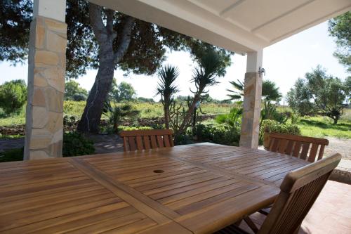 un tavolo e sedie in legno su un patio di case vacanze banchi a Carloforte