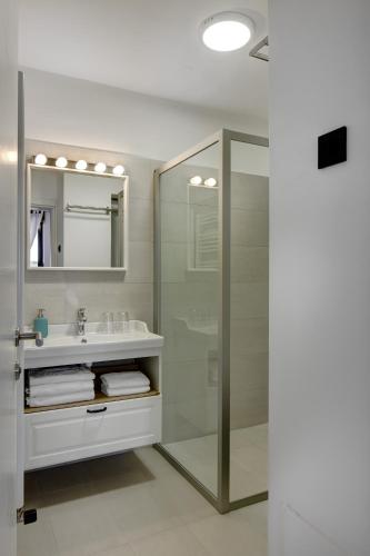 a bathroom with a glass shower and a sink at Apartments Viola in Zagreb
