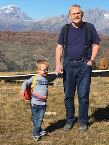 a man standing next to a little boy in a field at Haus Gentiana A in Grächen