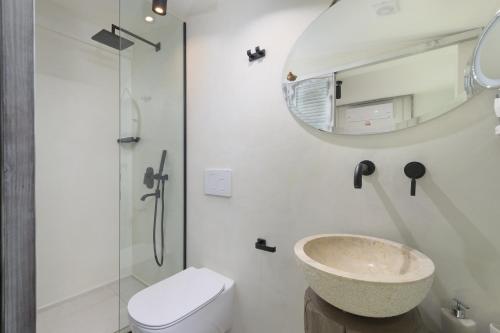 a bathroom with a sink and a toilet and a mirror at Albatross Beach Front Villas in Gennadi