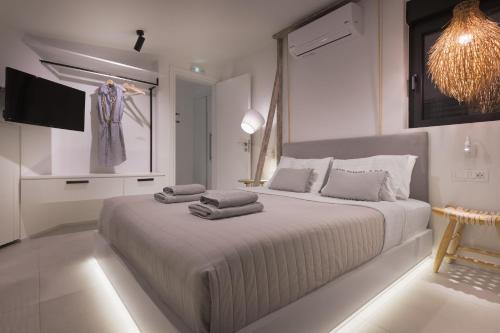 a white bedroom with a large bed with towels on it at Albatross Beach Front Villas in Gennadi