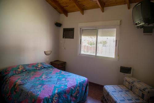 1 dormitorio con cama y ventana en Chalet para 9 personas en Monte Hermoso