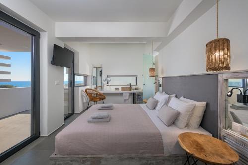a bedroom with a large bed and a table at Albatross Beach Front Villas in Gennadi