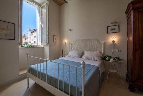 sypialnia z łóżkiem i dużym oknem w obiekcie La Residenza in Piazza Grande w mieście Foligno
