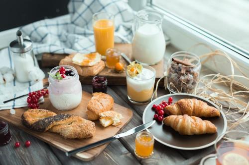 a breakfast table with croissants and other breakfast foods at Léa de Paris in Noisy-le-Grand