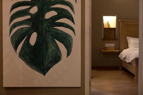 a painting of a plant on a wall next to a bedroom at Z.Garden in Dali