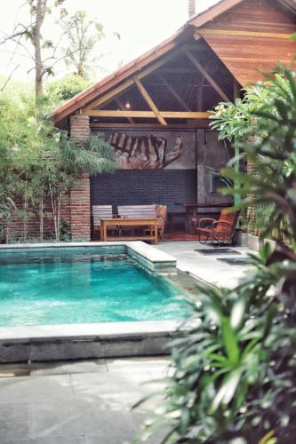 a swimming pool in front of a house at Pipes Hostel in Kuta Lombok