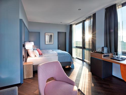 a bedroom with a bed and a desk and a chair at Panoramahotel Waldenburg in Waldenburg