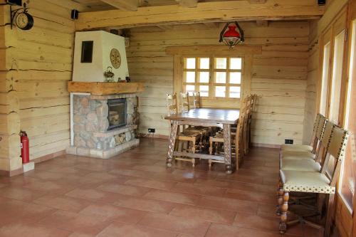 una sala da pranzo con tavolo e camino di Sodyba pas Olgą a Mickūnai