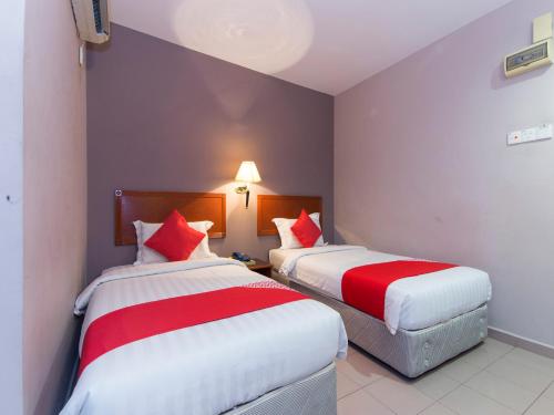 a hotel room with two beds with red and white sheets at Super OYO 484 Comfort Hotel Kapar in Klang