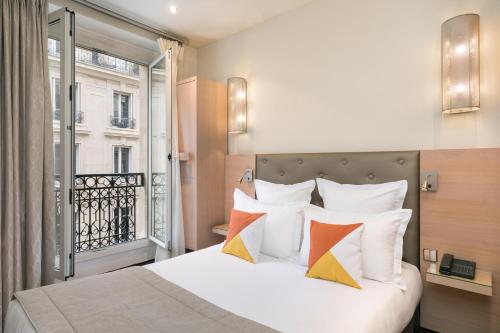 Un pat sau paturi într-o cameră la Hôtel Le Cardinal