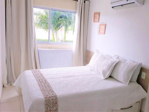 1 dormitorio con 1 cama blanca y ventana en Porto Plaza Flat Porto de Galinhas, en Porto de Galinhas
