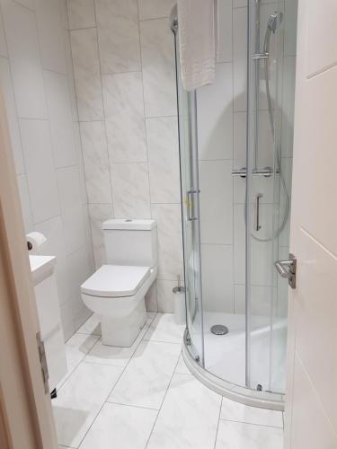 a white bathroom with a shower and a toilet at Soho Chambers by Indigo Flats in London