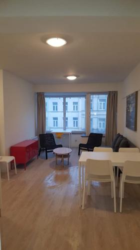 - un salon avec des tables, des chaises et un canapé dans l'établissement Central Appartment 2 bedrooms, à Bruxelles