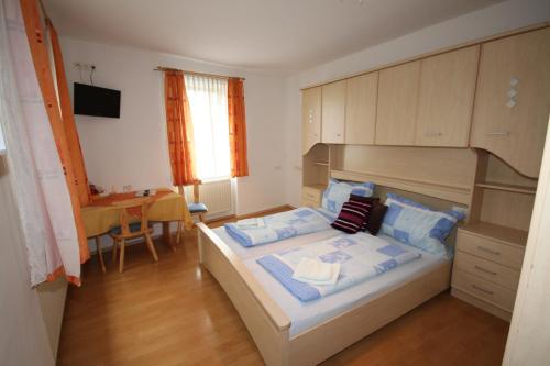 a bedroom with a large bed and a desk at Enns Sleep Gasthaus Backhendlstation in Enns