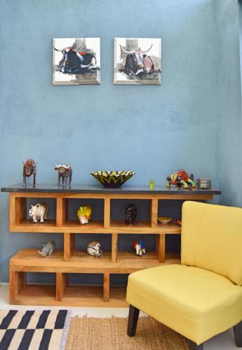 a living room with a table and a yellow chair at 1AA Wilhelmina Luxury Suites in Franschhoek