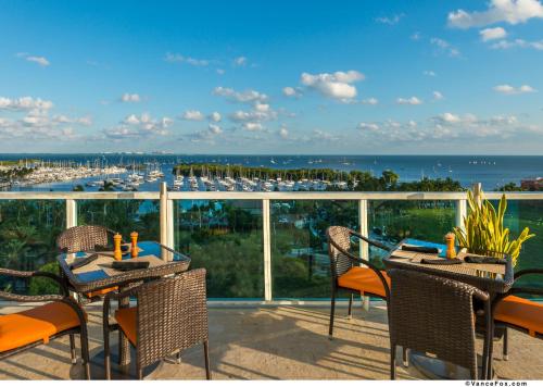 a balcony with tables and chairs and a view of a marina at Hotel Arya BW Premier Collection in Miami