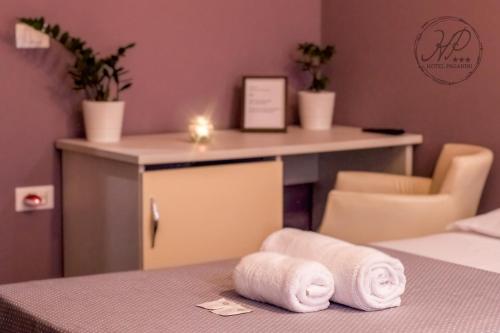 a room with two towels on a bed with a desk at Hotel Paganini in Florence