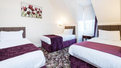 a hotel room with two beds and a window at The Atholl Palace in Pitlochry