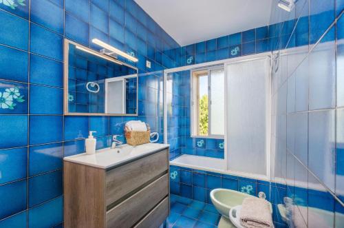 インカにあるVivienda Isabelaの青いタイル張りのバスルーム(シンク、鏡付)