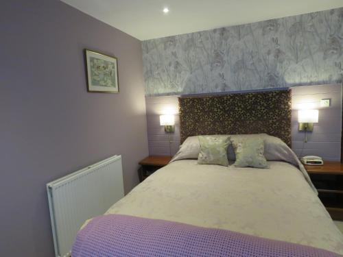 a bedroom with a large bed with two pillows at The Bay Horse Hotel And Restaurant in Ulverston