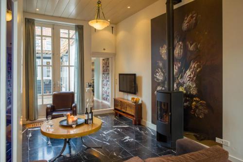 a living room with a fireplace and a tv at Tulpenhuis Enkhuizen in Enkhuizen