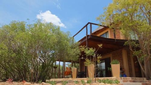 a house with trees in front of it at Baobab - NUDE - SunEden Family Naturist Resort in Pretoria