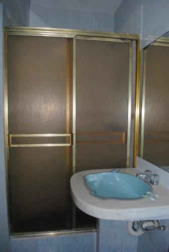 y baño con lavabo y ducha. en Hotel SKY, en Lima