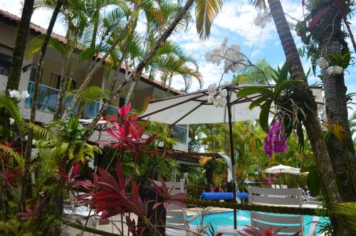 a resort with a swimming pool and palm trees at Apart Hotel Porto Kanoas in Bertioga