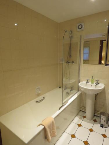 a bathroom with a tub and a sink and a shower at The Bay Horse Hotel And Restaurant in Ulverston