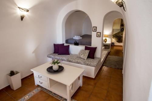 een woonkamer met een bed en een tafel bij Afroessa Hotel by Pearl Hotel Collection in Imerovígli