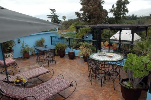 um pátio com uma mesa e cadeiras e uma mesa e cadeiras em Riad Lahboul em Meknès