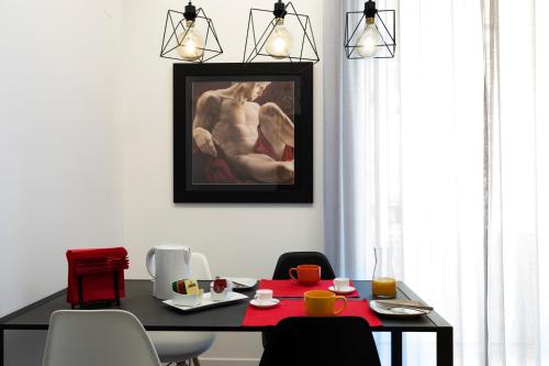 a dining room with a table and a painting on the wall at Acate81 Lifestyle Apartment in Naples